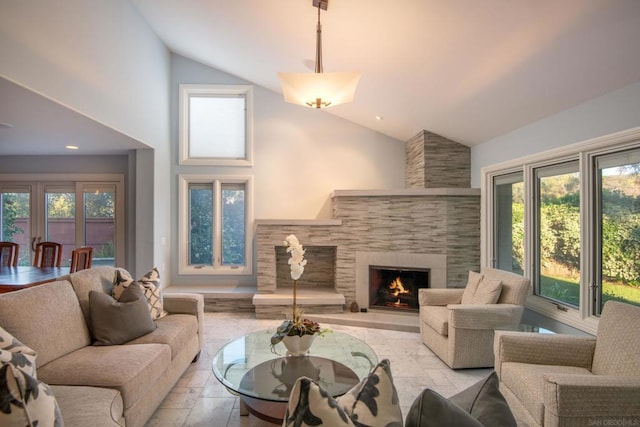 living room featuring a stone fireplace, a wealth of natural light, and high vaulted ceiling