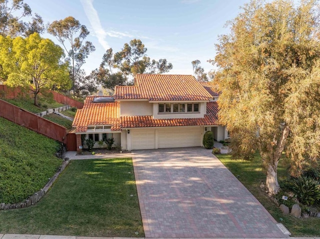 mediterranean / spanish-style home with a garage and a front lawn