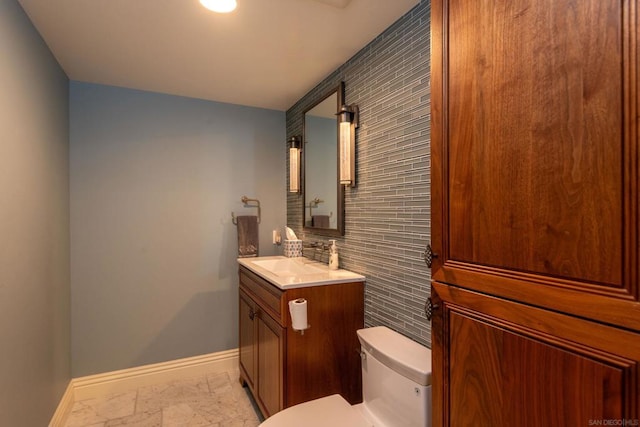 bathroom with vanity, decorative backsplash, and toilet