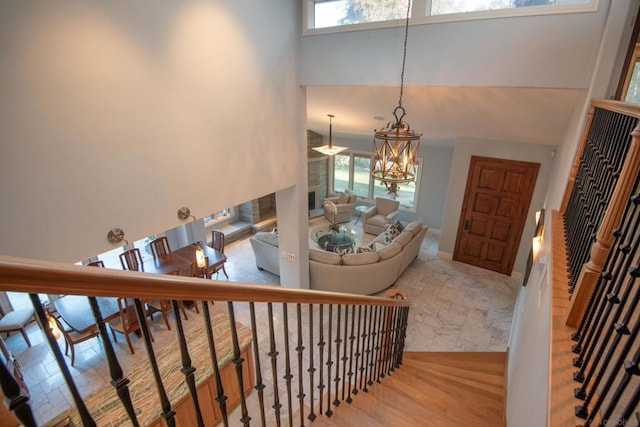 stairway featuring a notable chandelier, a towering ceiling, and hardwood / wood-style flooring