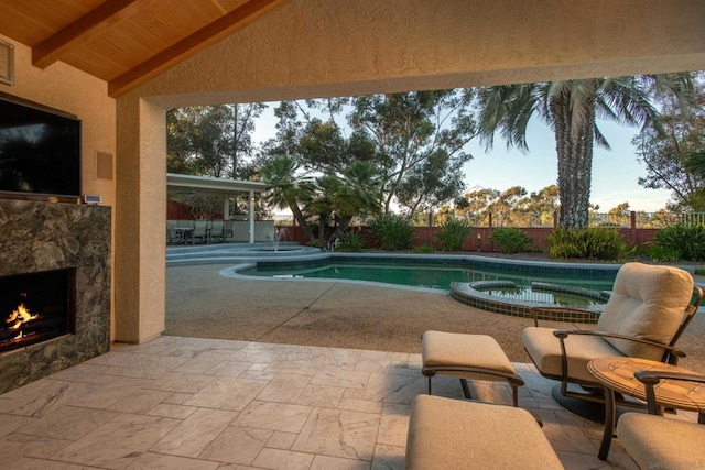 view of pool featuring an outdoor stone fireplace and a patio area