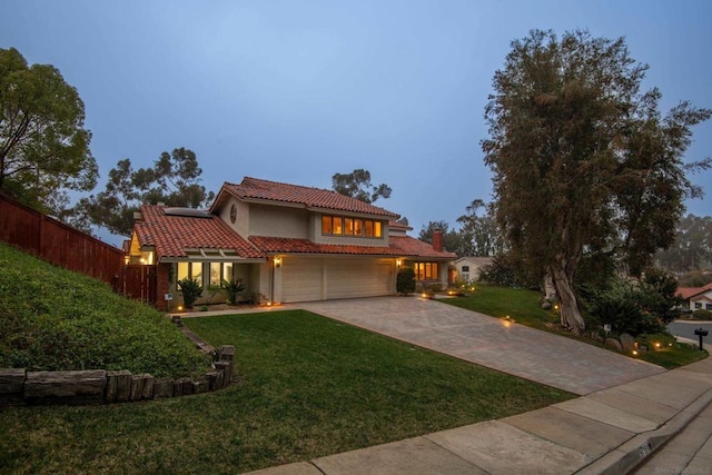 mediterranean / spanish-style house with a garage and a yard