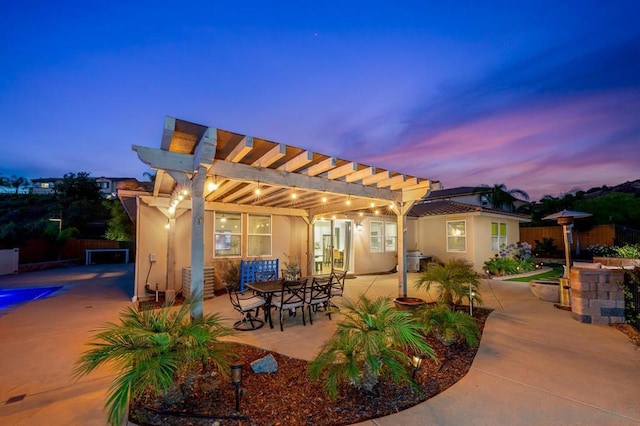 patio terrace at dusk featuring a pergola