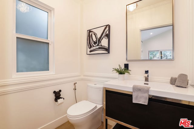 bathroom featuring vanity, vaulted ceiling, and toilet