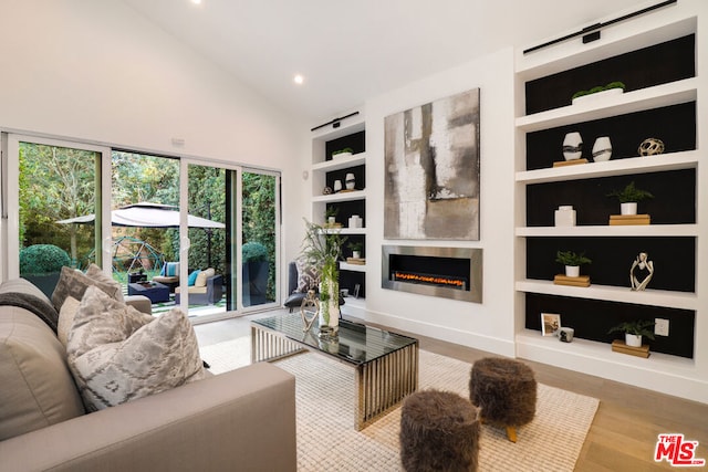 living room with wood-type flooring, high vaulted ceiling, and built in shelves