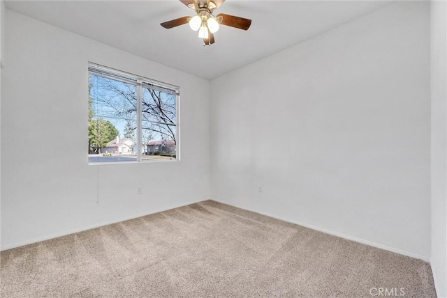 carpeted spare room with ceiling fan