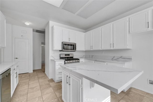 kitchen featuring white cabinetry, stainless steel appliances, a kitchen breakfast bar, and a kitchen island