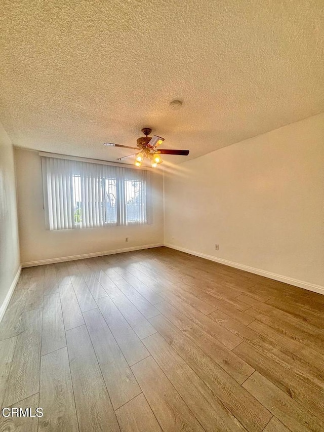 unfurnished room with a textured ceiling, wood-type flooring, and ceiling fan