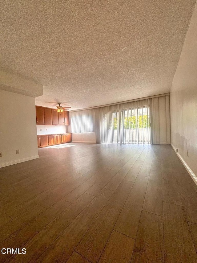 spare room featuring a textured ceiling, wood-type flooring, and ceiling fan