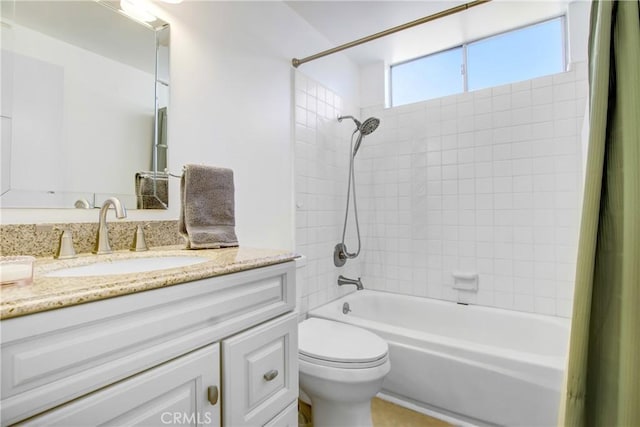 full bathroom featuring vanity, tiled shower / bath combo, and toilet