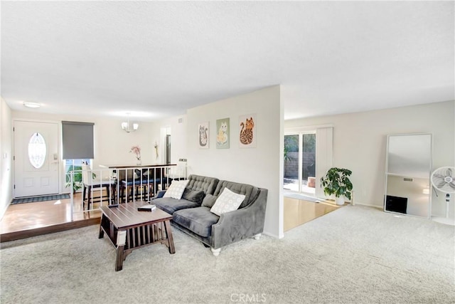 carpeted living room featuring a chandelier