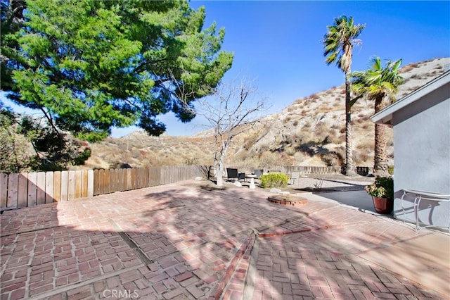 view of patio with a mountain view and a fire pit