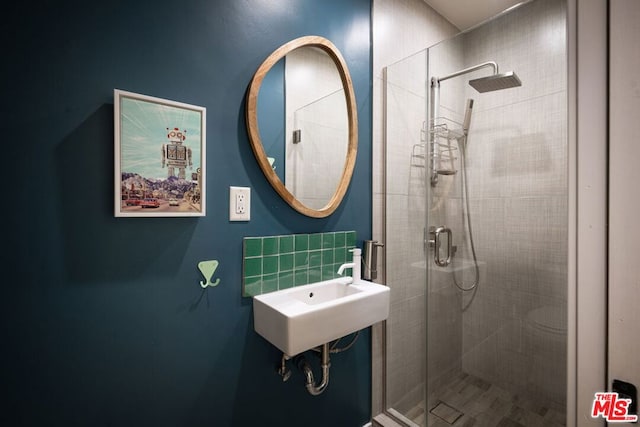 bathroom featuring sink and a shower with door