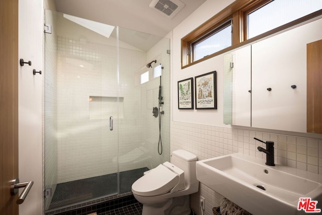 bathroom featuring sink, tile walls, an enclosed shower, vaulted ceiling, and toilet