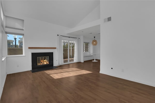 unfurnished living room with high vaulted ceiling and dark hardwood / wood-style floors