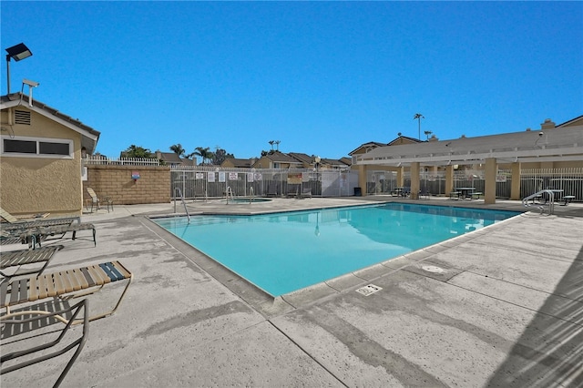 view of swimming pool with a community hot tub and a patio