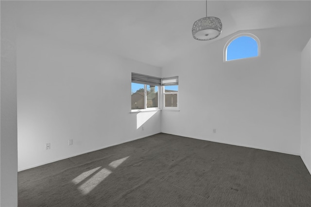 unfurnished room with dark carpet and high vaulted ceiling