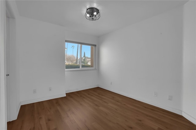 spare room with dark hardwood / wood-style floors