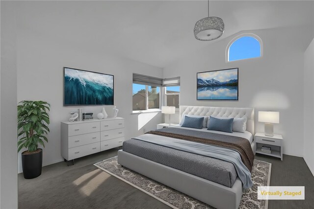 bedroom with dark colored carpet and high vaulted ceiling