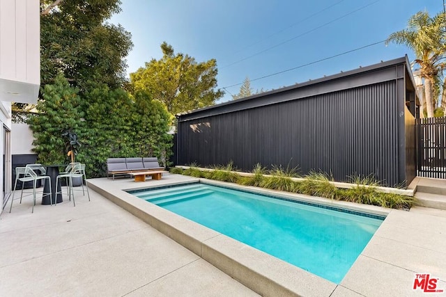 view of pool with outdoor lounge area and a patio