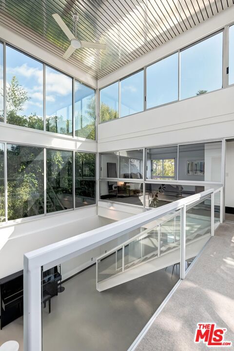 unfurnished sunroom with ceiling fan