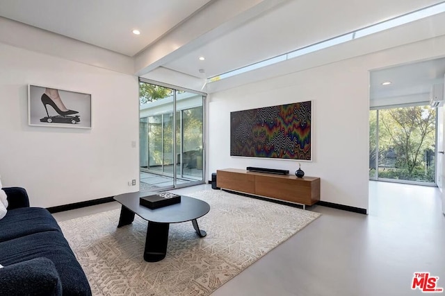 living room with beamed ceiling and concrete floors