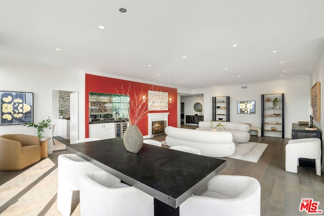 living room featuring hardwood / wood-style floors, crown molding, and beverage cooler