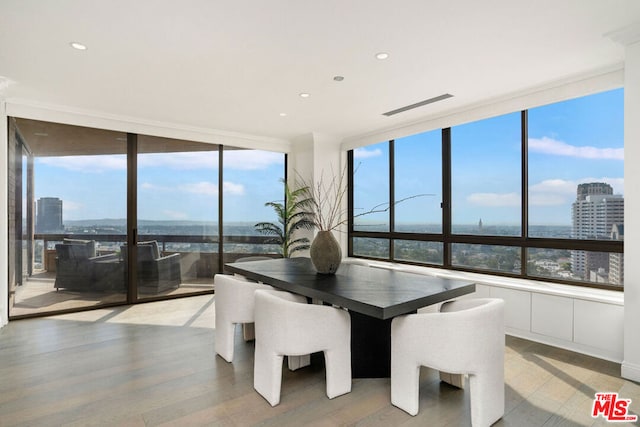 dining room with expansive windows, light hardwood / wood-style floors, and a wealth of natural light