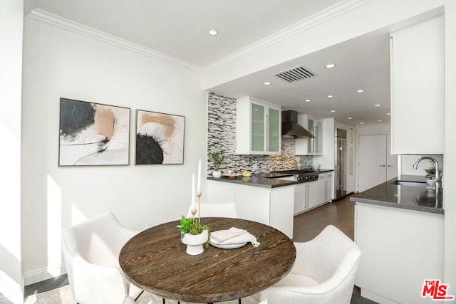 dining space with crown molding and sink