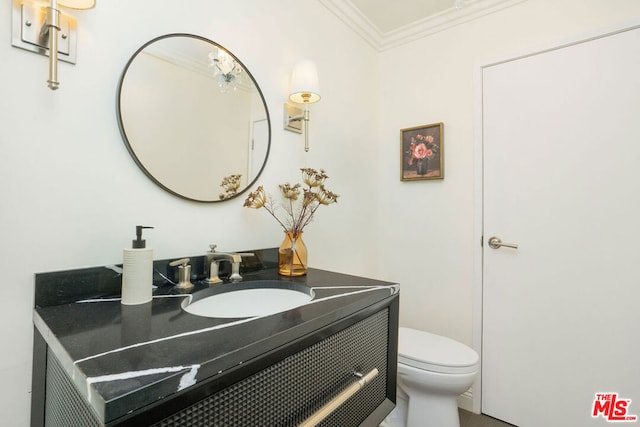 bathroom with crown molding, vanity, and toilet