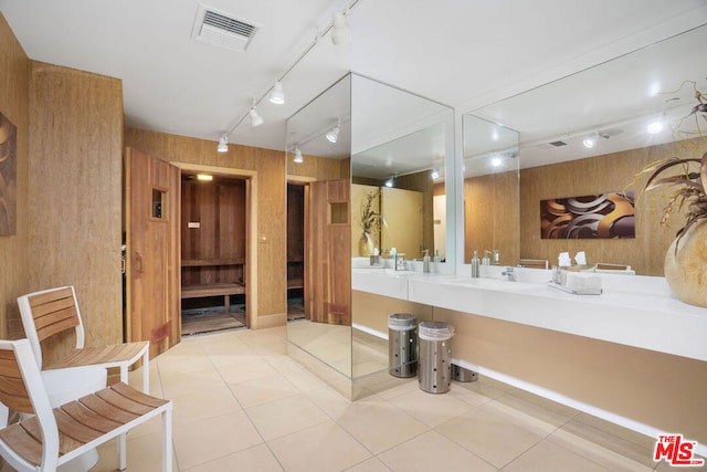 bathroom with tile patterned flooring, vanity, track lighting, and wooden walls