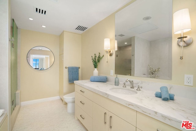 bathroom featuring vanity, toilet, and walk in shower