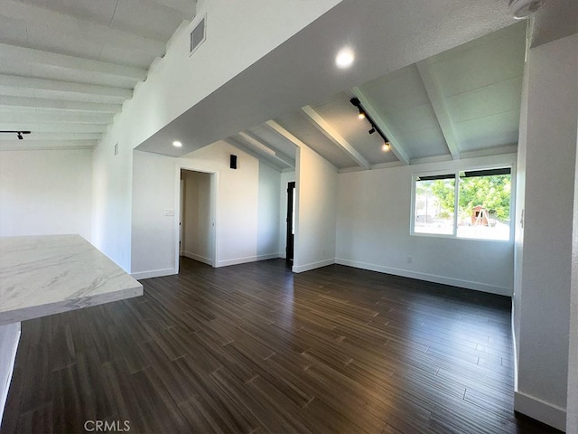 unfurnished room featuring rail lighting, lofted ceiling with beams, and dark hardwood / wood-style floors