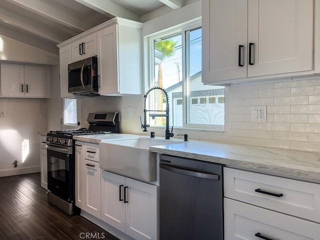 kitchen featuring sink, white cabinetry, dark hardwood / wood-style floors, stainless steel appliances, and decorative backsplash