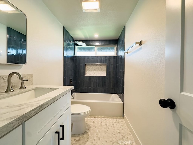 full bathroom featuring vanity, tiled shower / bath combo, and toilet