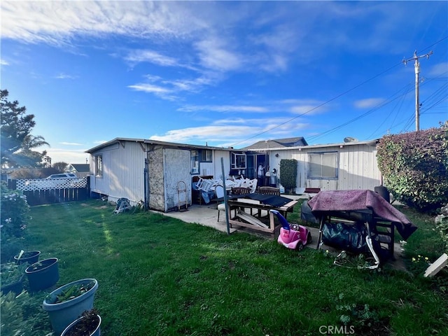 rear view of house with a patio and a lawn