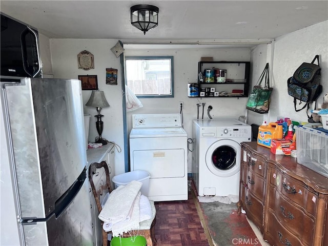 laundry area with dark parquet floors and washer and clothes dryer