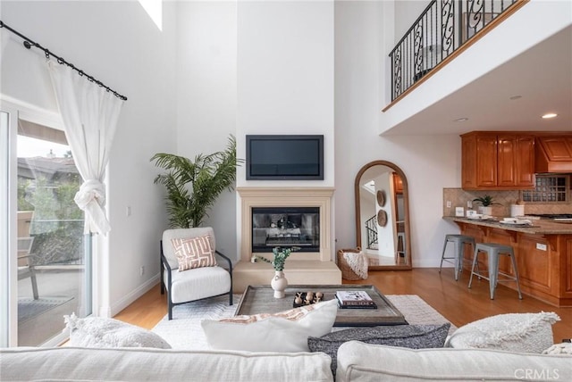 living room with a high ceiling and light wood-type flooring