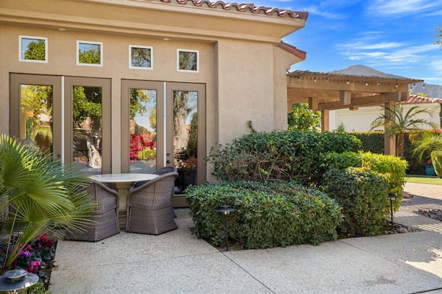 entrance to property featuring a pergola and a patio area