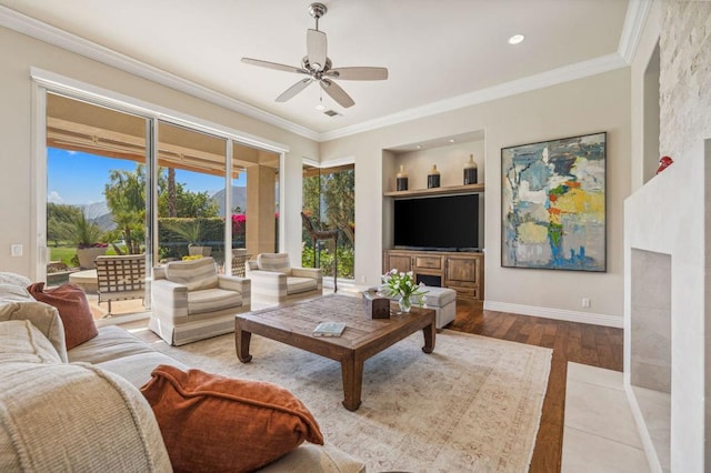 living room with built in features, light hardwood / wood-style flooring, ornamental molding, and ceiling fan