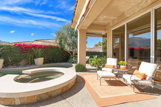 view of patio featuring a pool with hot tub and a mountain view