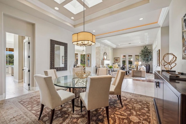 dining area featuring light tile patterned floors, an inviting chandelier, a skylight, ornamental molding, and a raised ceiling