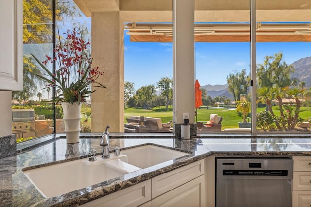 kitchen featuring a mountain view, sink, stainless steel dishwasher, and white cabinets