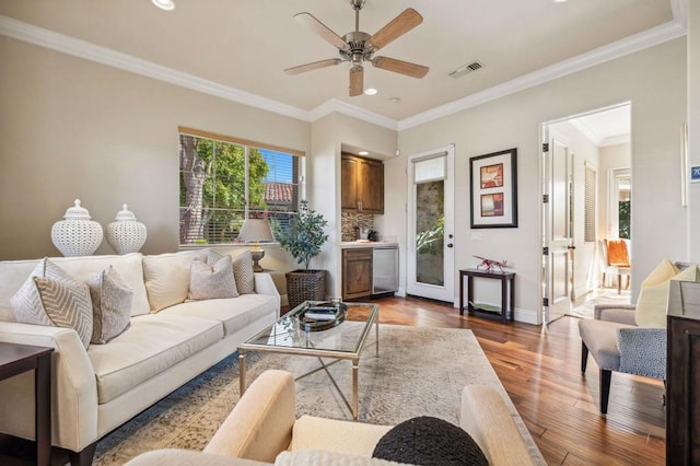 living room featuring crown molding, hardwood / wood-style floors, and ceiling fan