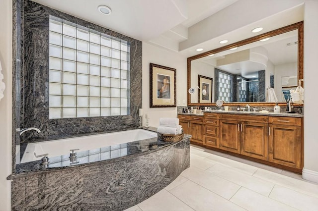 bathroom with vanity, tiled bath, and tile patterned floors