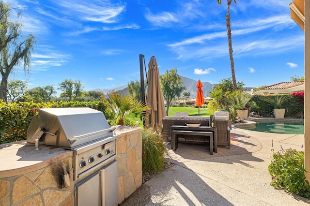 view of patio / terrace featuring area for grilling, a mountain view, and outdoor lounge area