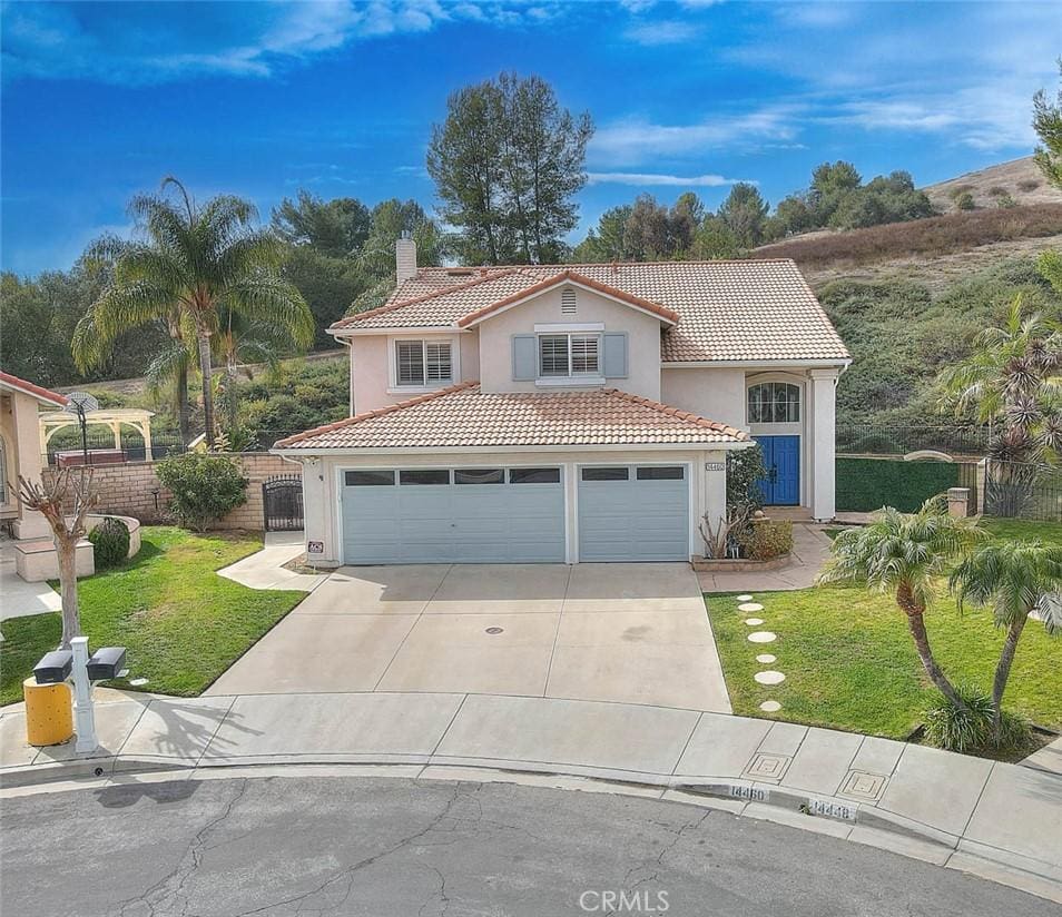 mediterranean / spanish-style house featuring a garage and a front lawn