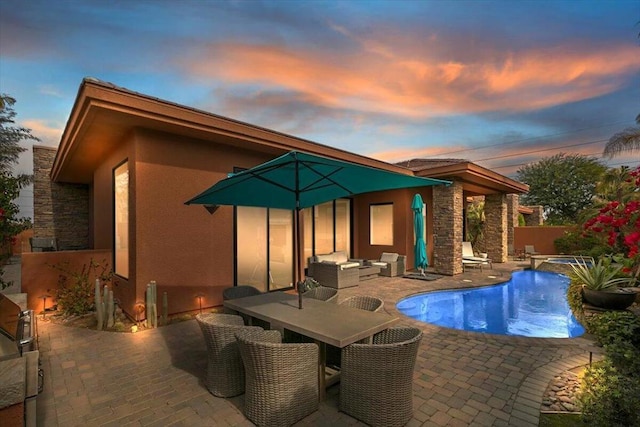 pool at dusk featuring a patio