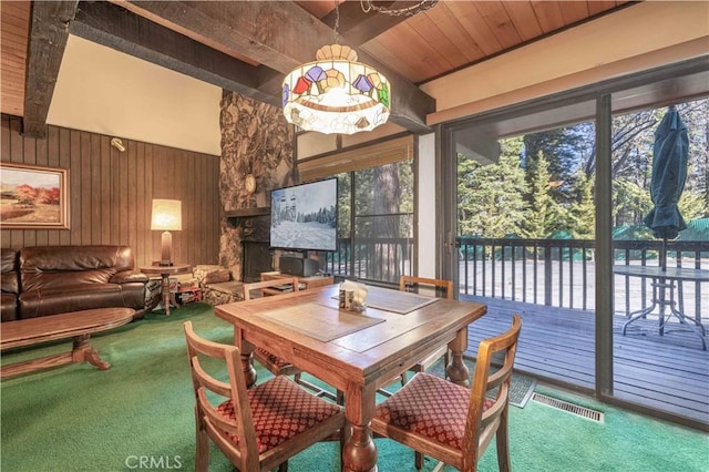 sunroom / solarium with beamed ceiling, wooden ceiling, and a fireplace