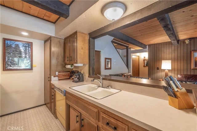 kitchen with wood walls, dishwasher, sink, wood ceiling, and beam ceiling